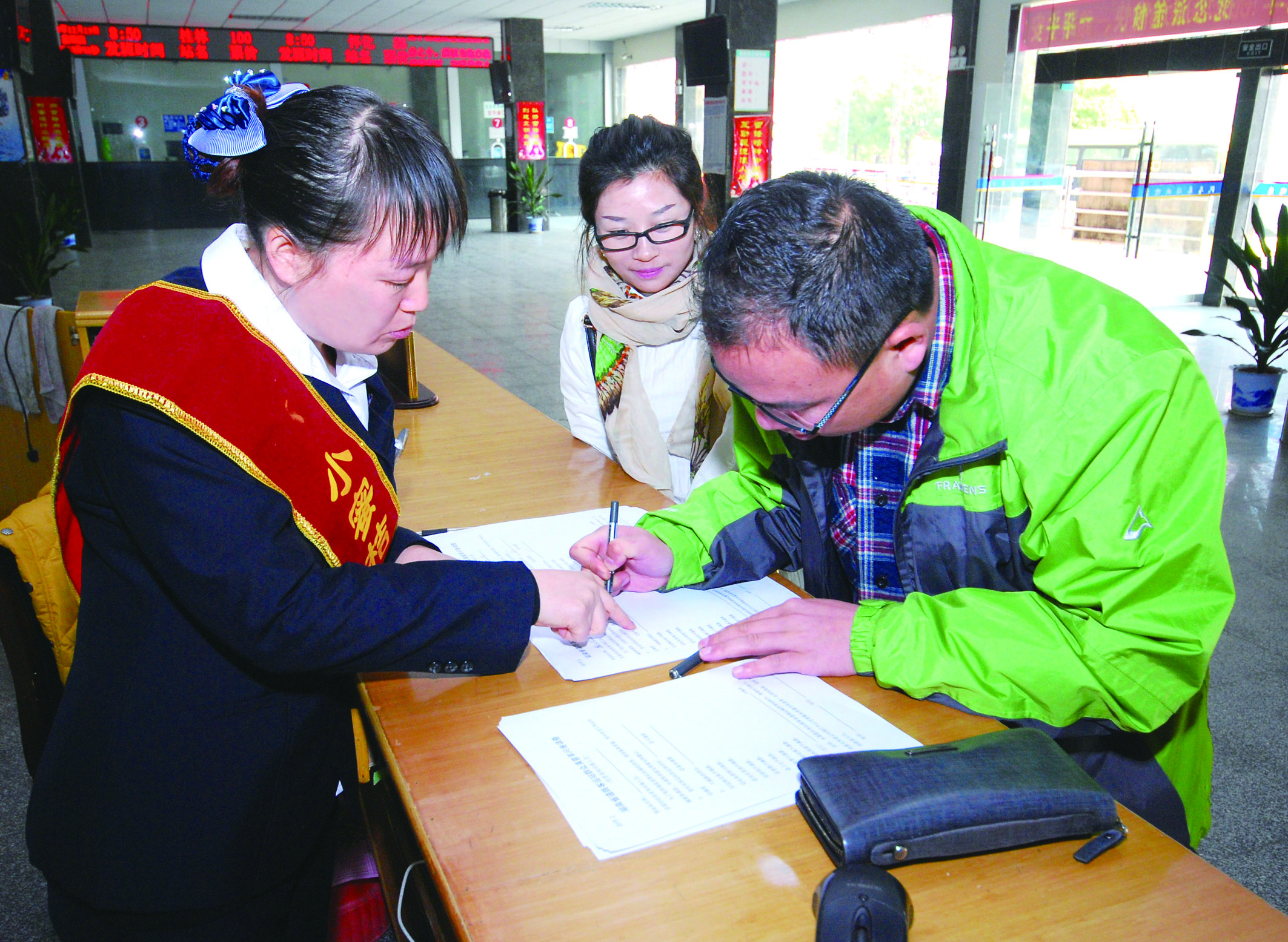 圖為洞口汽車總站站務(wù)人員在熱心為旅客服務(wù)。